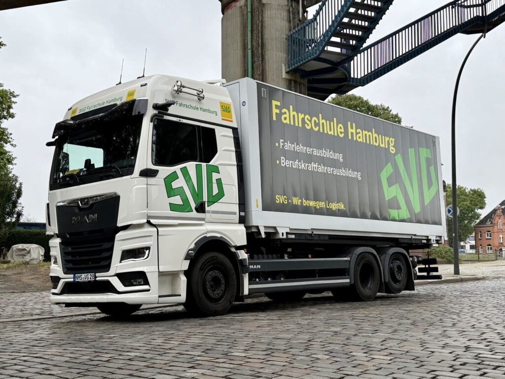 Weisser MAN Lastwagen der SVG Fahrschule Hamburg auf Kopfsteinpflaster