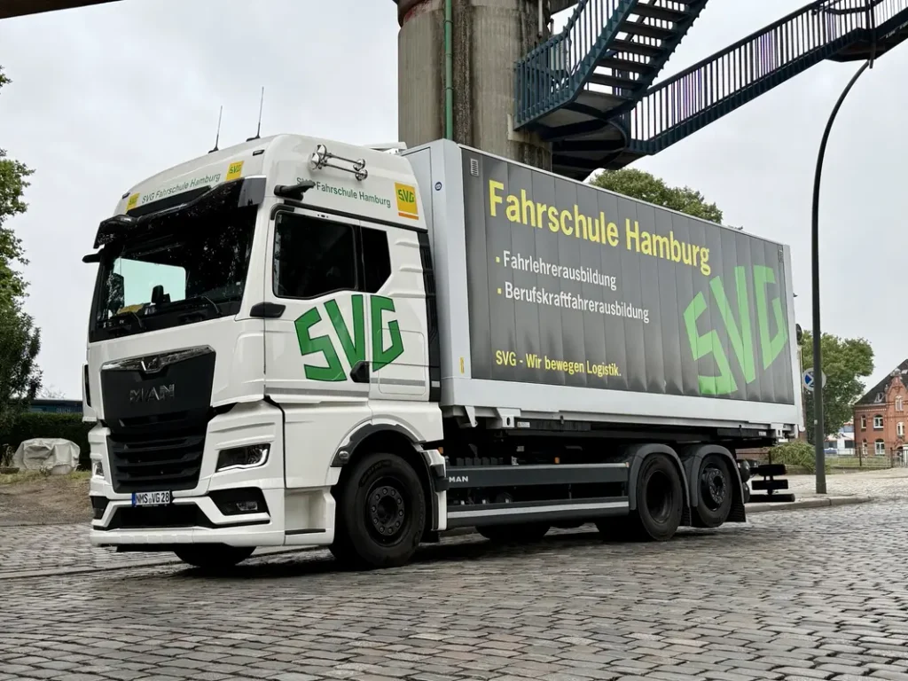 Weisser MAN Lastwagen der SVG Fahrschule Hamburg auf Kopfsteinpflaster